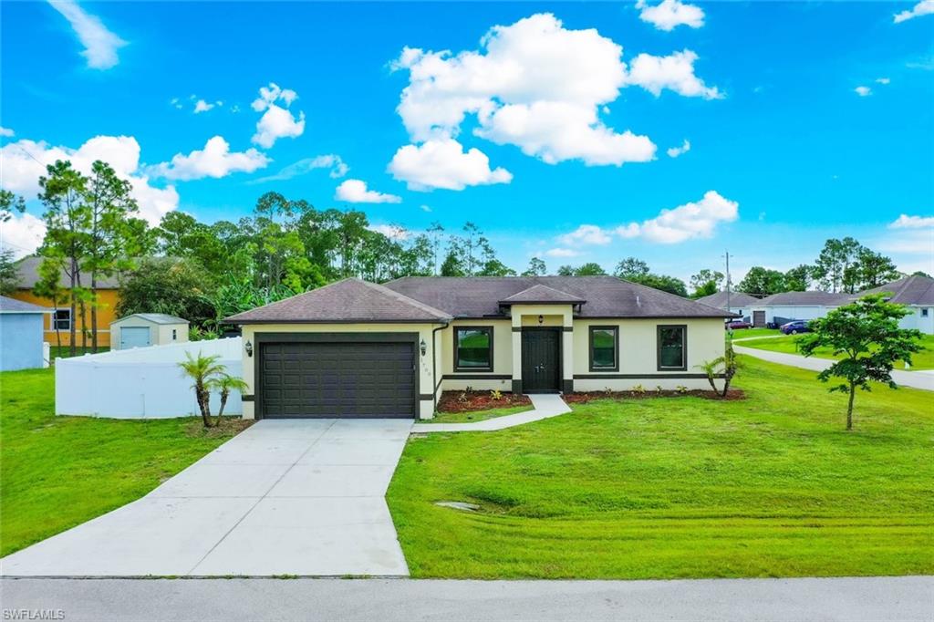 Single-story residence with a concrete driveway, attached two-car garage, and a lush green lawn