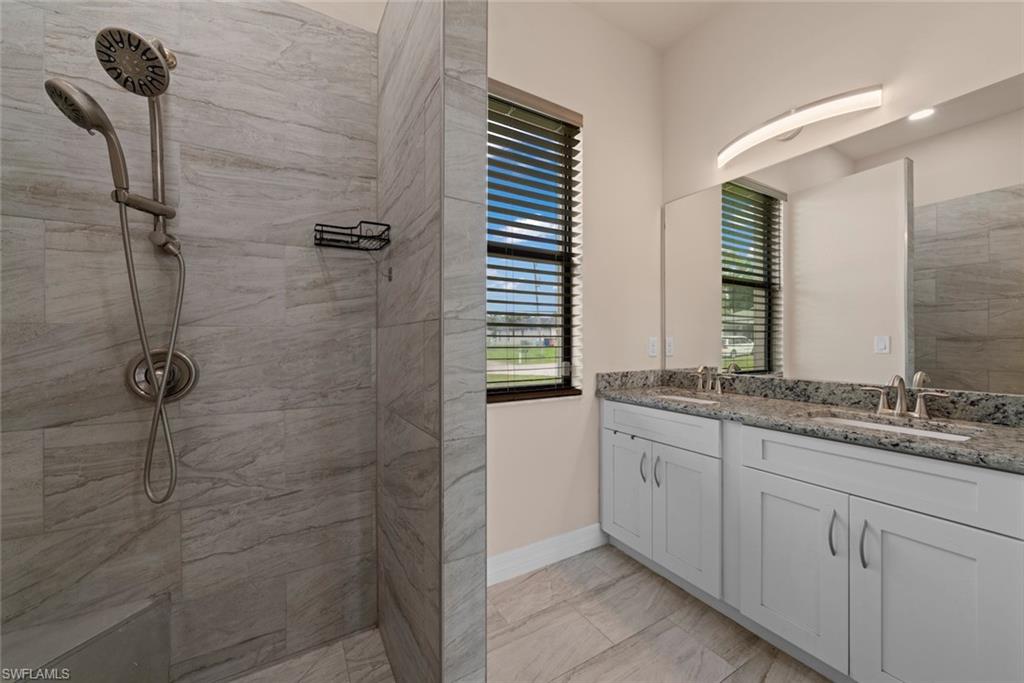 Dual vanity with undermount sinks, granite countertops, and light wood-finish cabinetry
