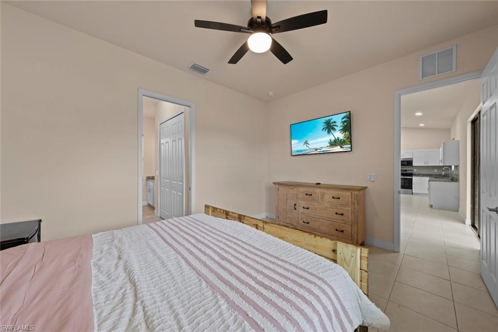 Primary bedroom suite with a ceiling fan and tiled flooring