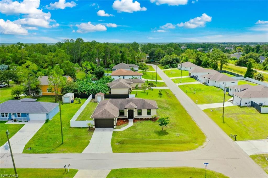 Single-story residence featuring a two-car garage, white privacy fencing, and a concrete driveway