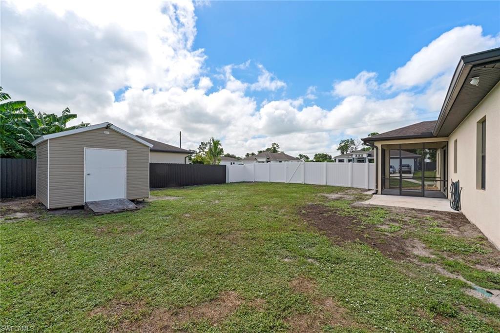 Expansive backyard featuring a storage shed, screened lanai, and privacy fencing