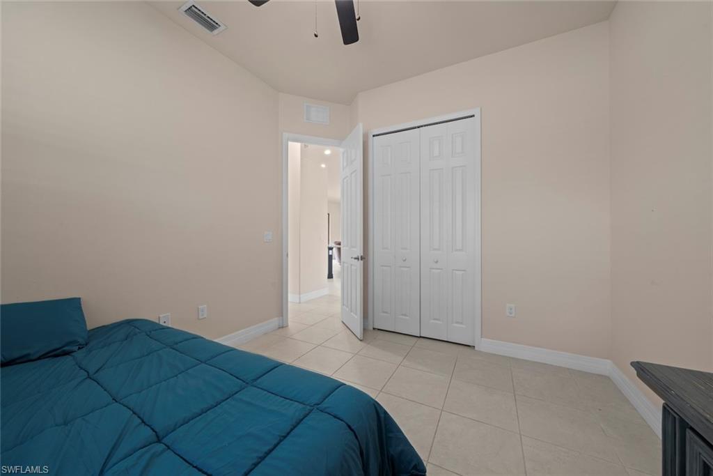 Room featuring light-colored walls, tile flooring, and a ceiling fan