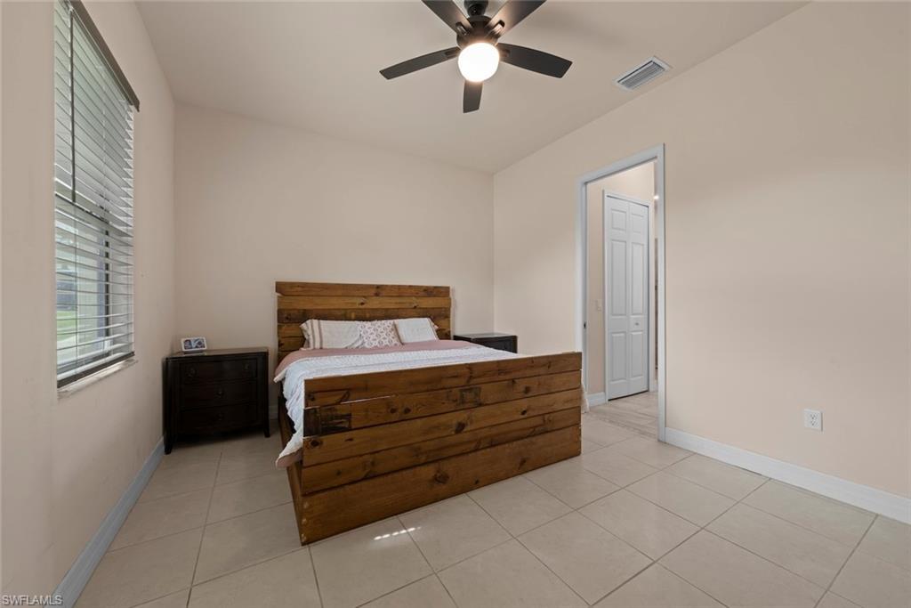 Tiled flooring, vaulted ceiling, ceiling fan with integrated lighting, and a window for natural light