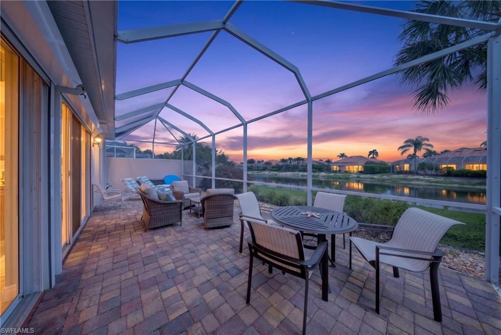 Screened lanai featuring paver flooring, a sliding glass door entry, and a water-facing orientation