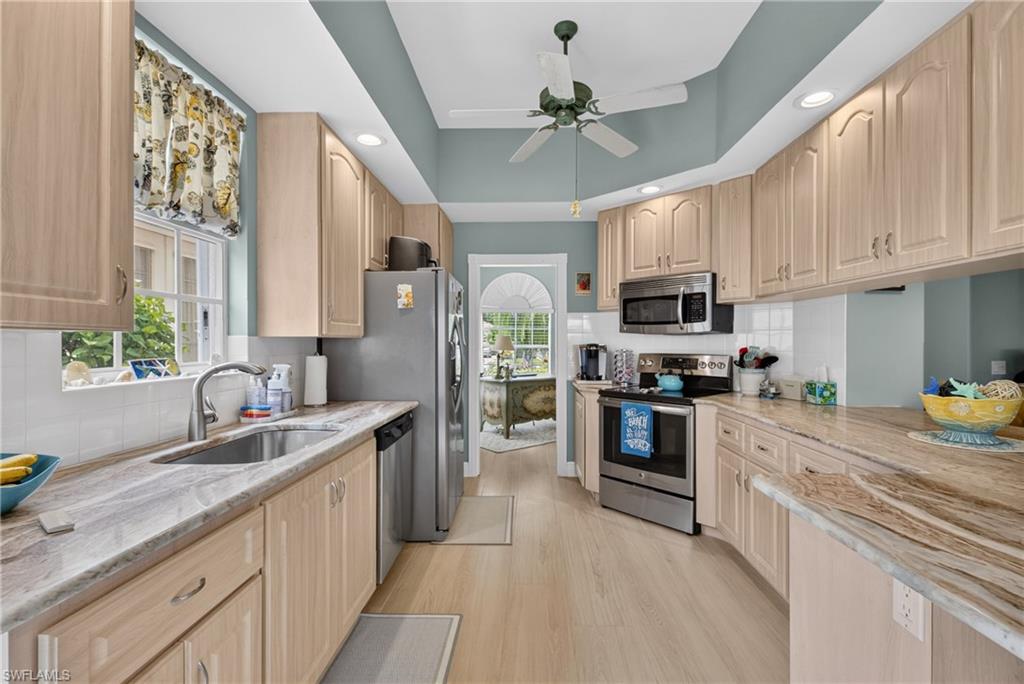 Kitchen featuring wood-finish cabinetry, light-toned countertops, and stainless steel appliances