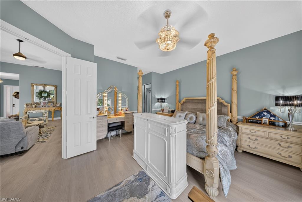 Spacious room featuring wood-finish flooring, vaulted ceilings, and a decorative ceiling fan with lighting