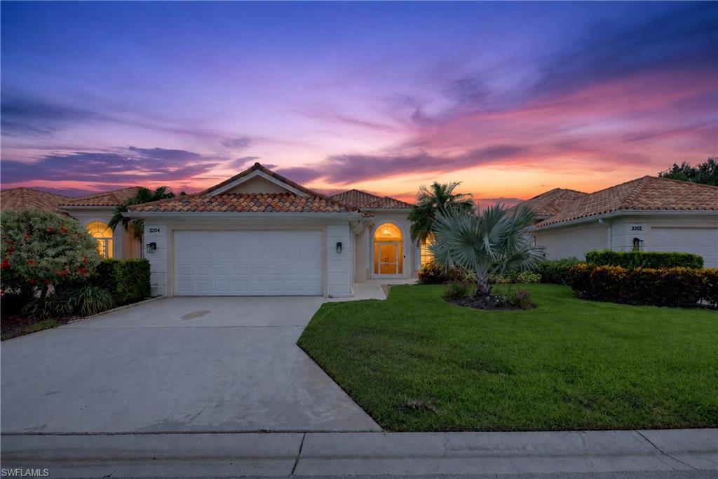 Mediterranean-style residence featuring a tile roof, arched entryway, and an integrated garage