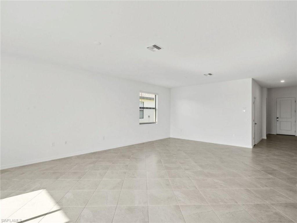 Spacious primary bedroom with tile flooring and plenty of natural light.