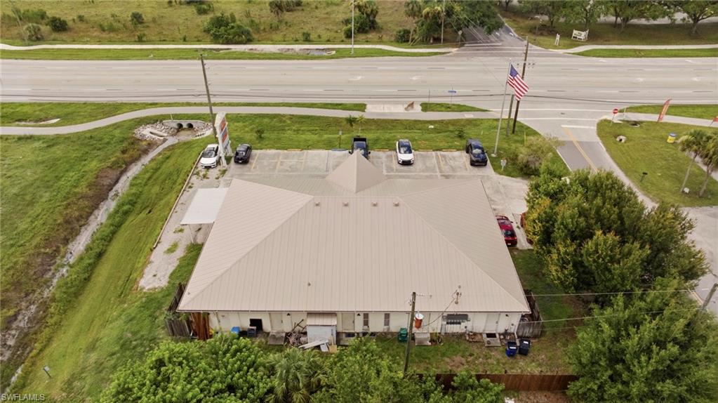 Commercial property with a metal roof, paved parking area, and mature perimeter landscaping