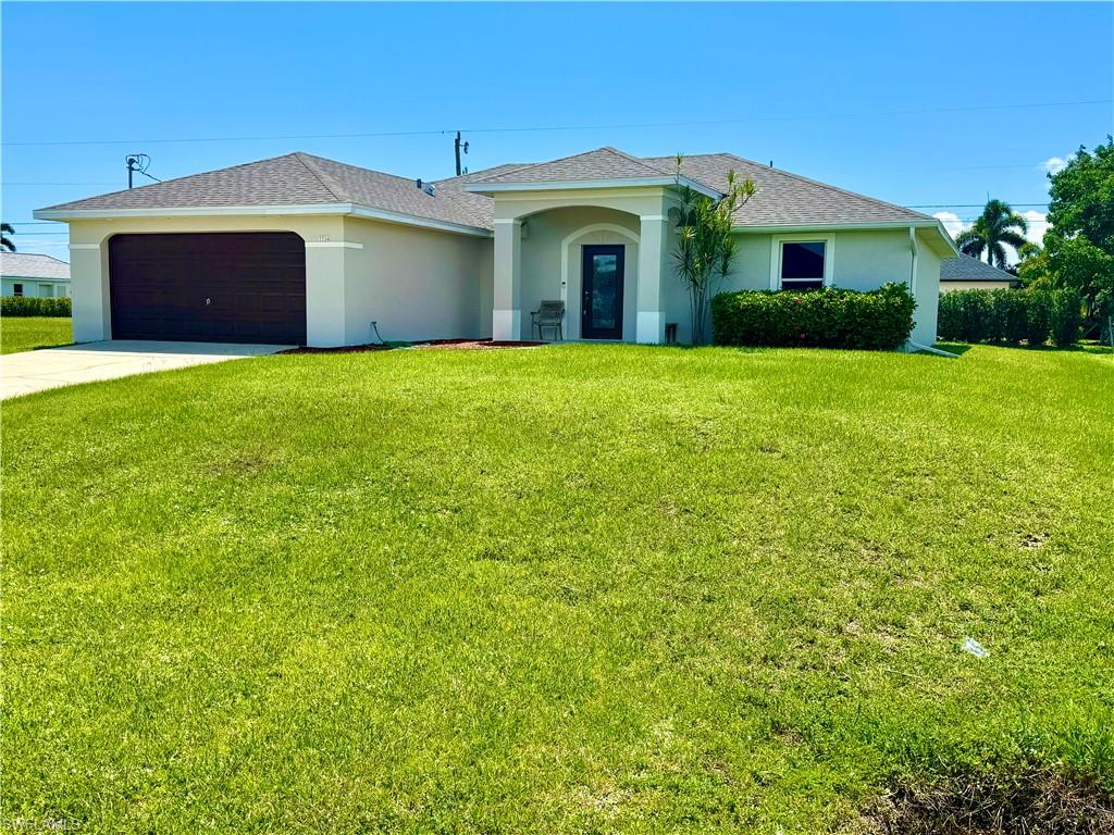 Ranch-style house with stucco siding, roof with shingles, concrete driveway, a front yard, and a garage