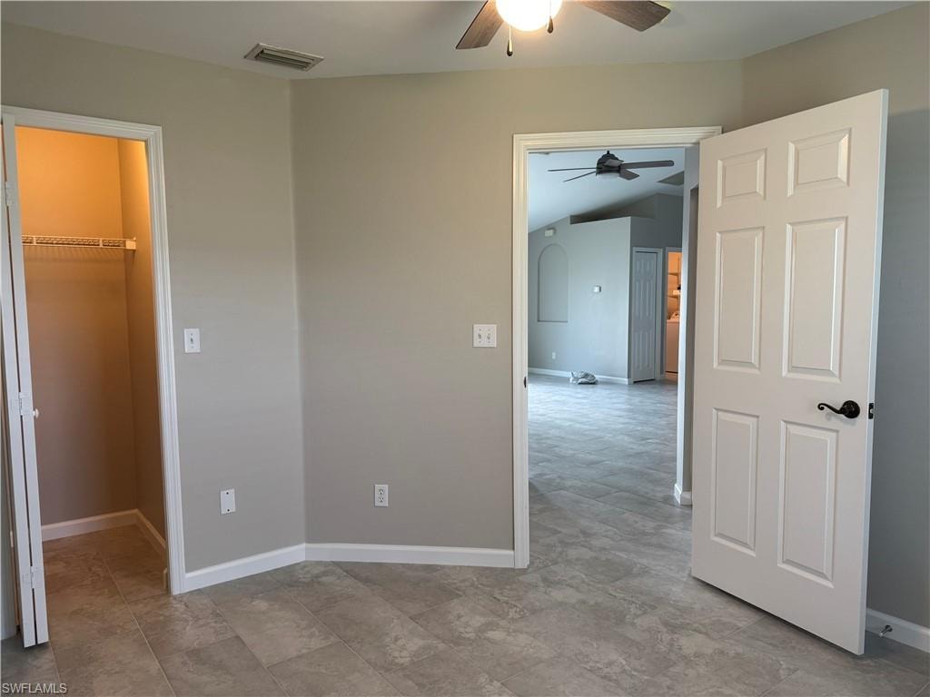 Third bedroom featuring a walk in closet and ceiling fan