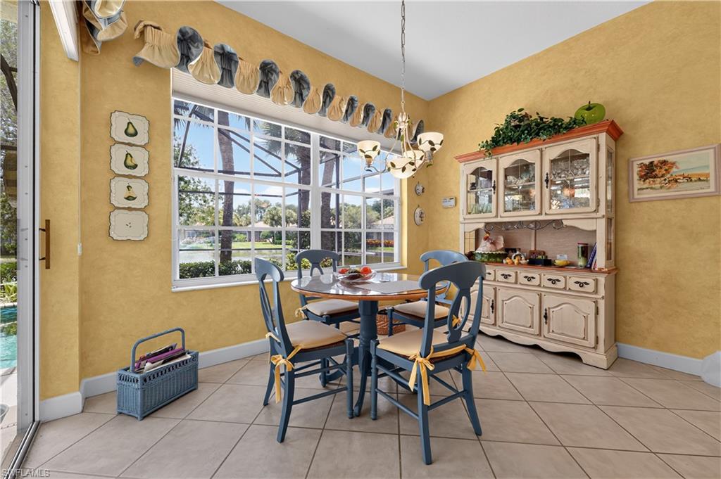 Dining area featuring a large window overlooking a waterway, tiled flooring, and a built-in display hutch