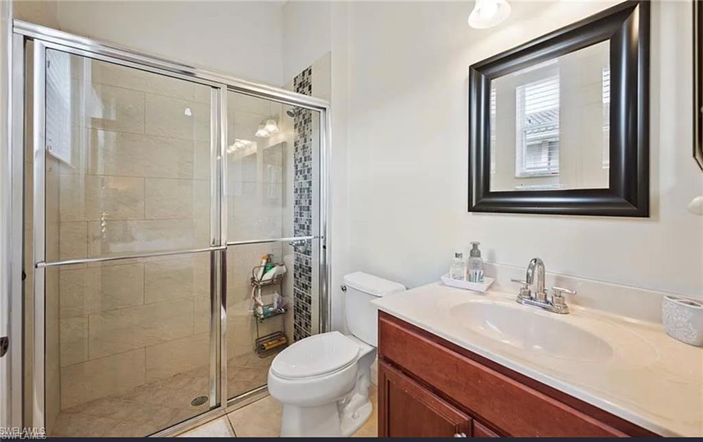 Glass-enclosed shower with tile surround and mosaic accent