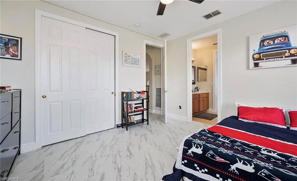 White paneled bi-fold closet doors, ceiling fan, and light-toned flooring
