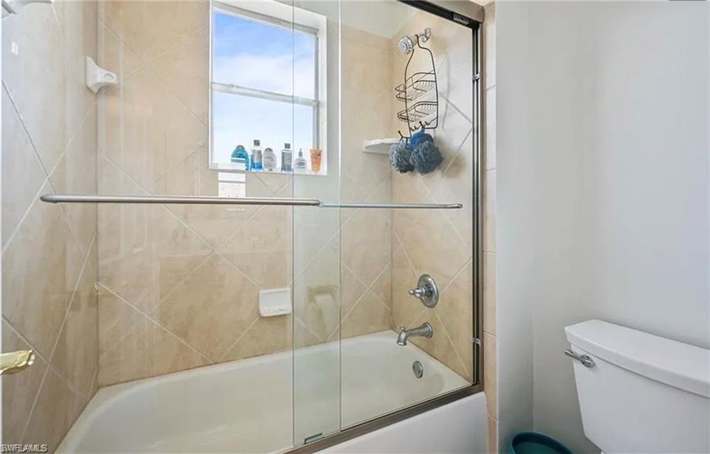 Bathtub with glass enclosure and chrome fixtures
