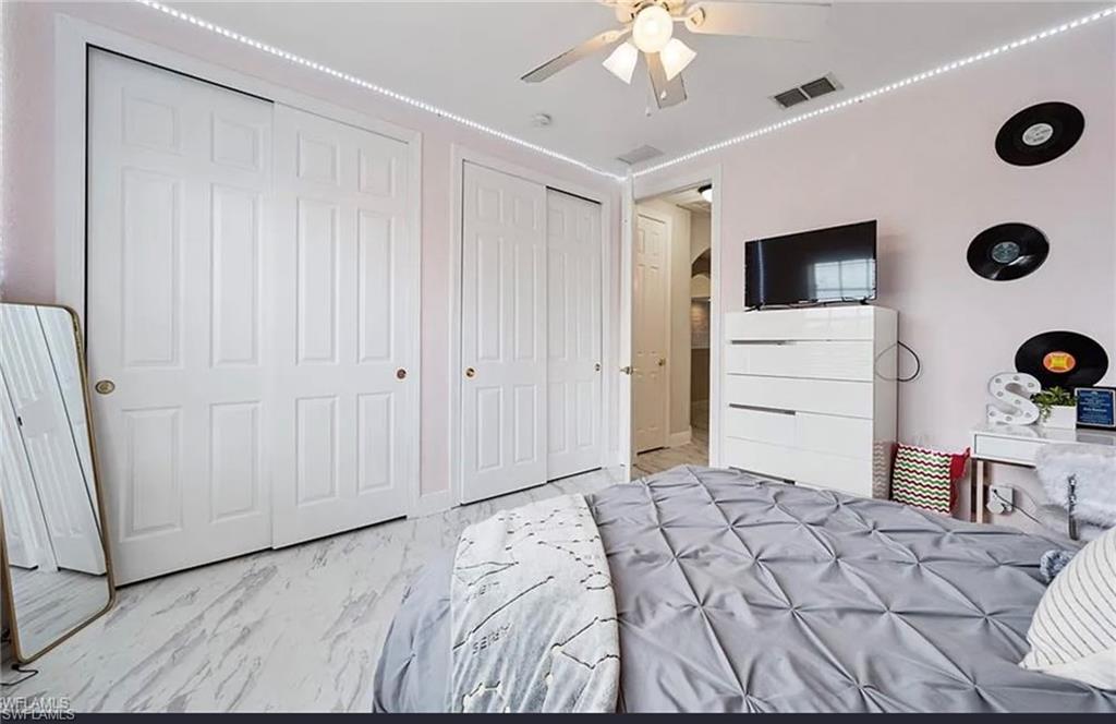White panel doors, ceiling fan, and light-toned flooring