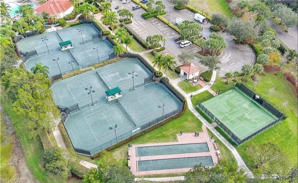 Multiple tennis courts with fencing and lighting