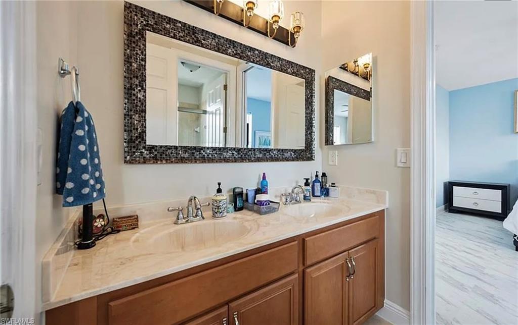 Double vanity with integrated sinks, a light-toned countertop, and wood-finish cabinetry