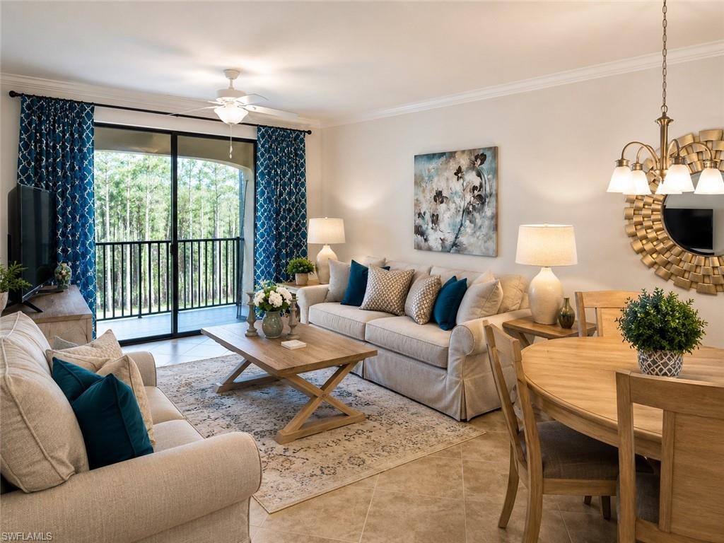 Open-concept living area with tile flooring, a built-in ceiling fan, and crown molding