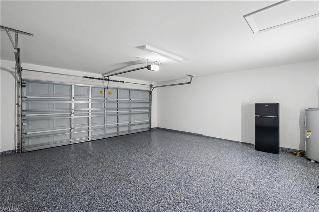 Epoxy coated garage floor, single overhead garage door, overhead lighting, access panel, and painted walls
