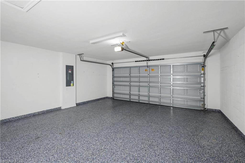 Garage with an epoxy floor, white walls, and a panel-style garage door