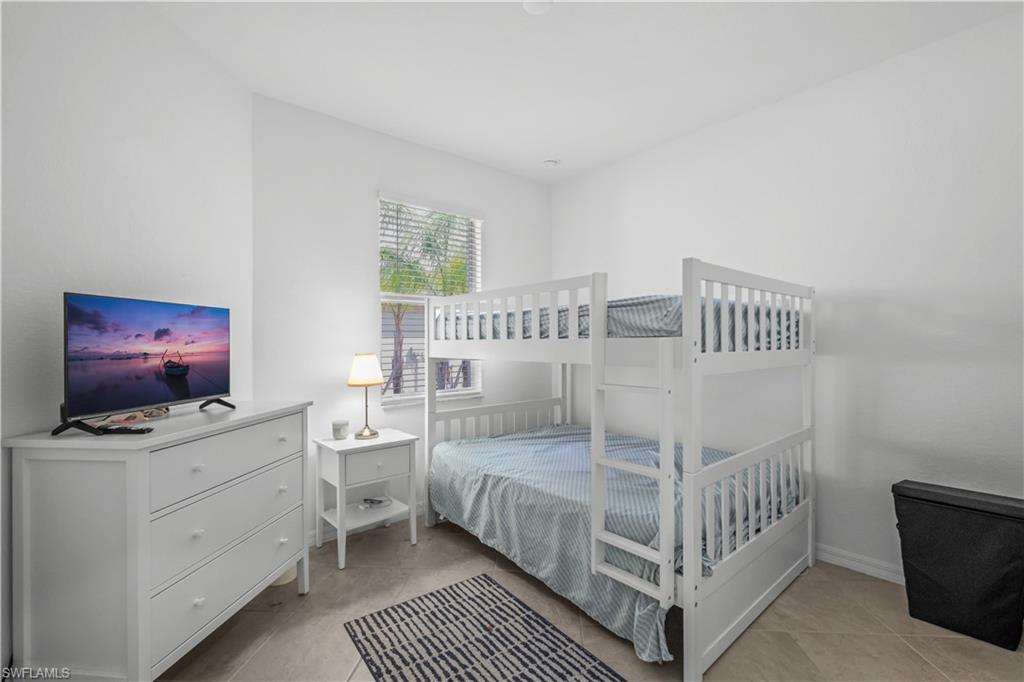 Second BedroomWhite walls featuring a window with blinds, tile flooring, and a built-in bunk bed