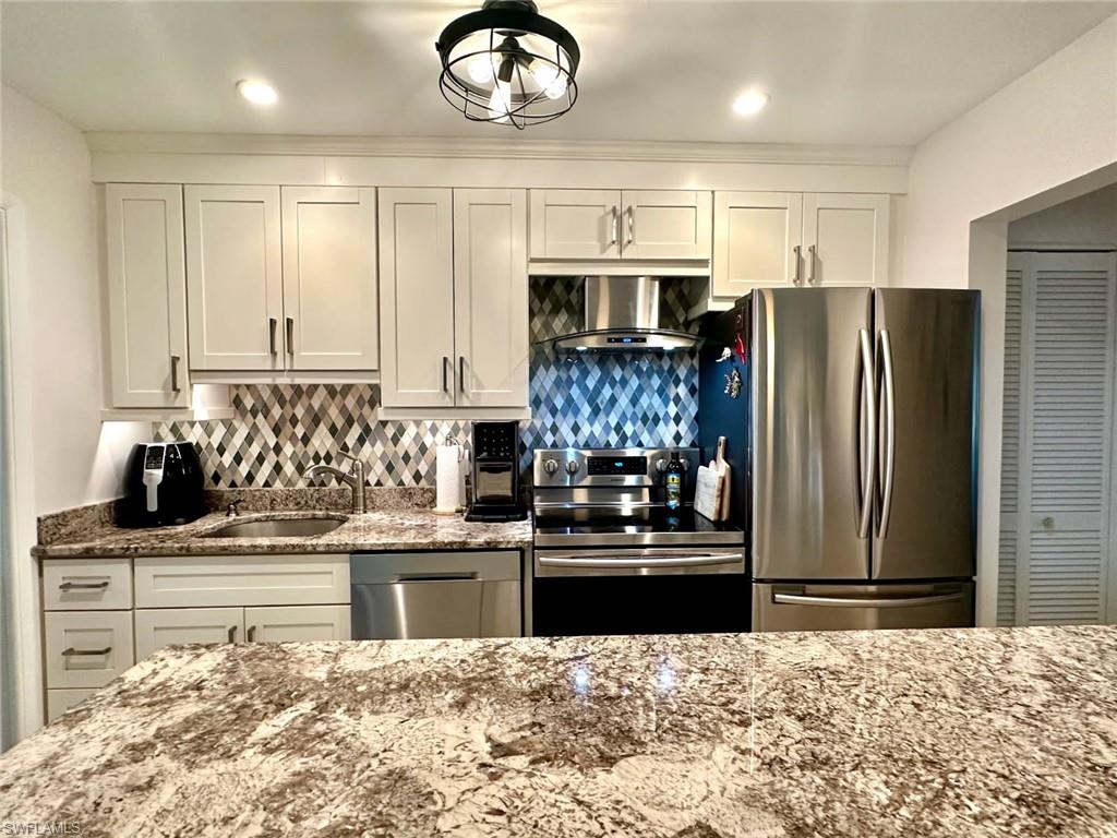 Customized kitchen and Cabinetry featuring light stone counters, stainless steel appliances, and tasteful backsplash