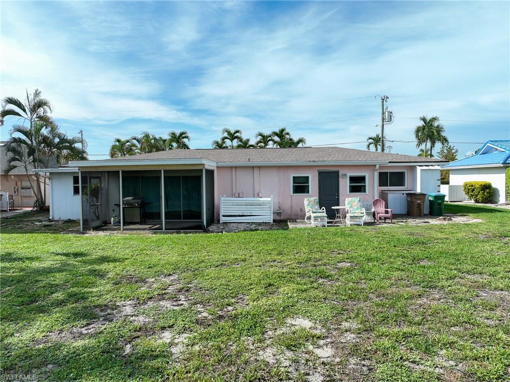 Spacious single-story residence with a covered porch and multiple glass-panel doors opening to an expansive lawn