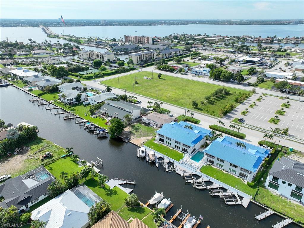 Waterfront property with private boat docks, canal access, a private swimming pool, and a blue roof