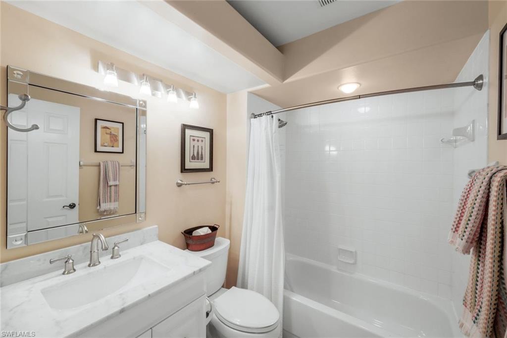 Bathroom with shower / bathtub combination with curtain and vanity