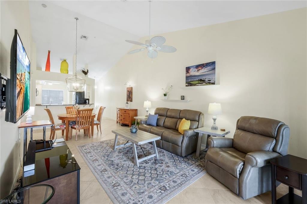 Living room TV, Soundbar, featuring high vaulted ceiling, light tile patterned floors, and a ceiling fan