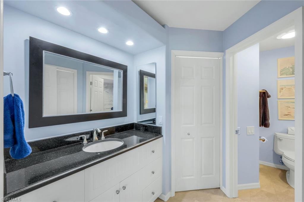Bathroom featuring vanity, light tile patterned floors, recessed lighting, and a closet