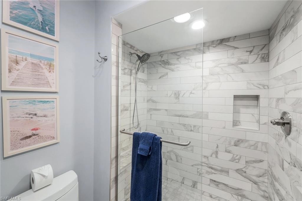 Full bath featuring toilet and a shower stall
