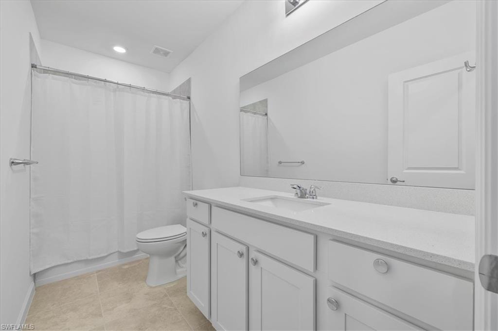 Full bathroom with vanity, toilet, recessed lighting, baseboards, and tile patterned flooring