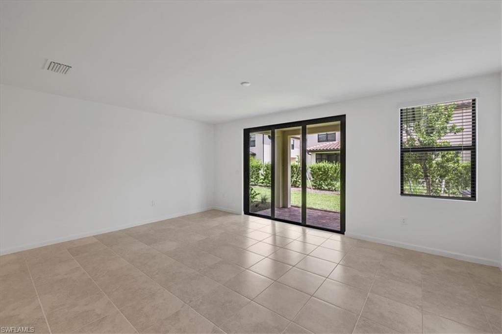 Unfurnished room featuring plenty of natural light, light tile patterned floors, and baseboards