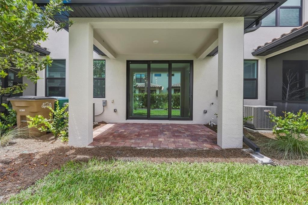 Property entrance featuring stucco siding, central air condition unit, and a patio