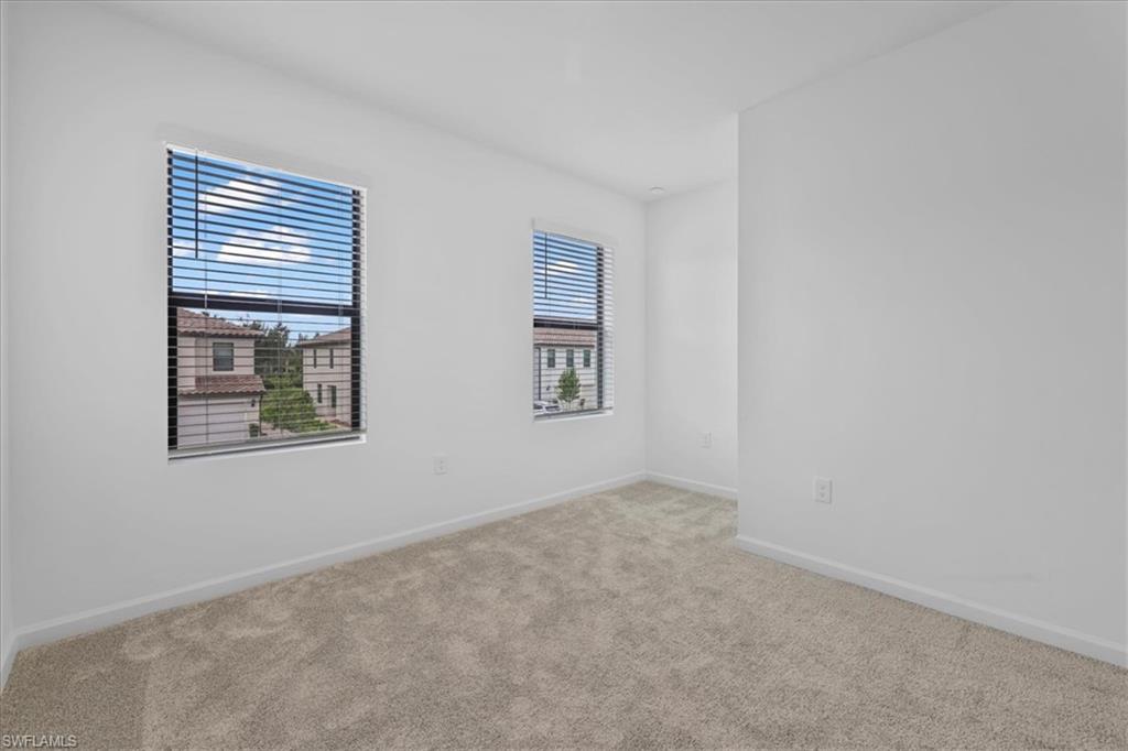 Carpeted spare room with baseboards