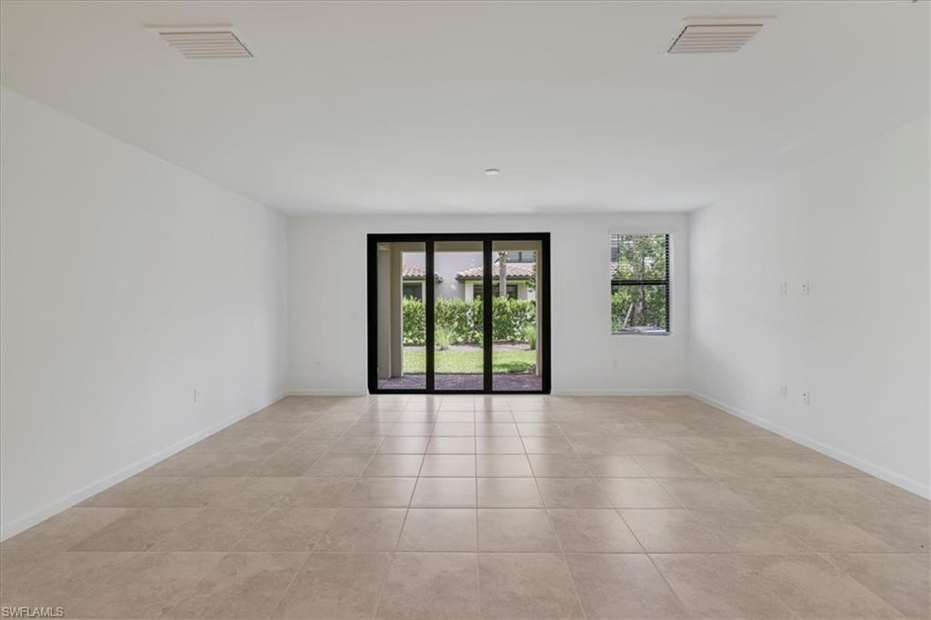 Spare room with light tile patterned floors and baseboards