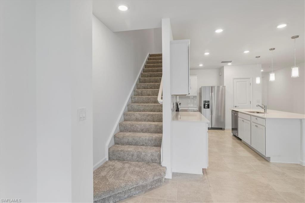 Stairs featuring tile patterned floors, recessed lighting, and baseboards