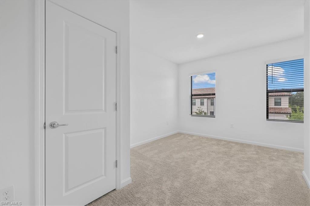 Spare room with light carpet, baseboards, and recessed lighting
