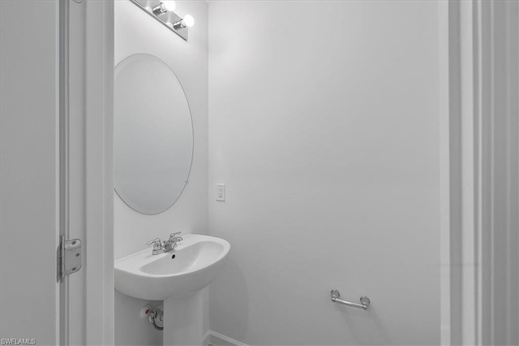 Bathroom featuring baseboards and a sink