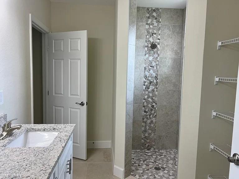 Spa-inspired primary bathroom featuring a granite-topped vanity with an undermount sink, mosaic tile accent wall in the walk-in shower, and heated towel rails