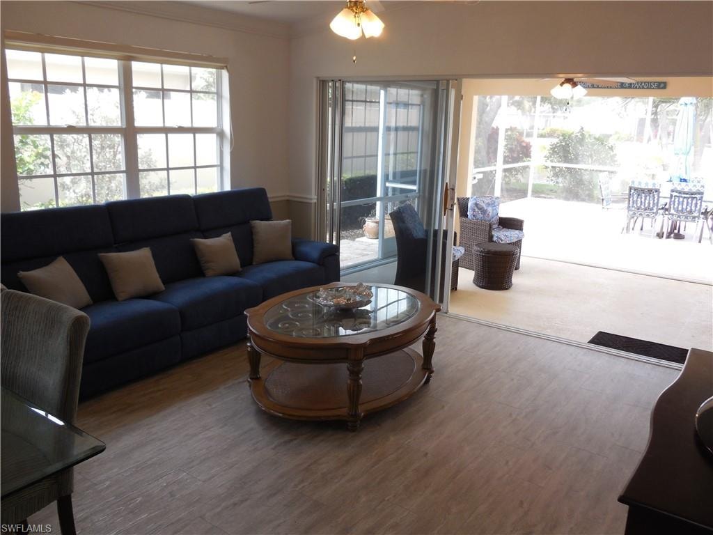 Living area featuring ornamental molding, a ceiling fan, and wood finished floors