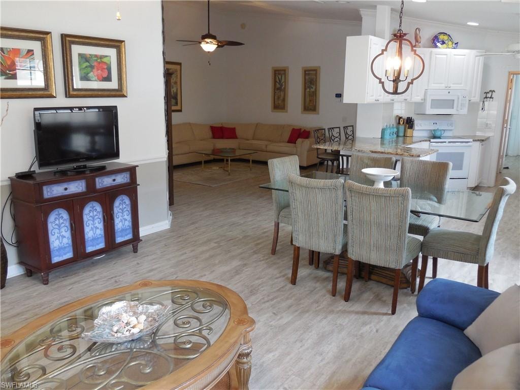 Dining room featuring crown molding, ceiling fan with notable chandelier, and light wood finished floors