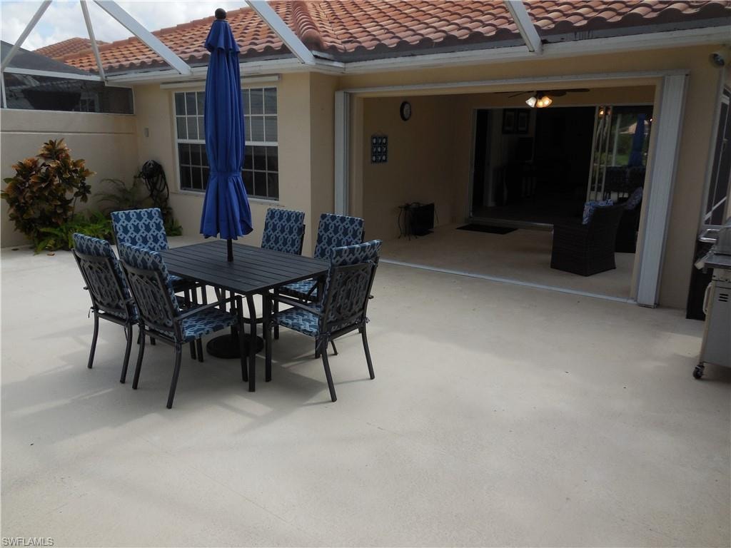 View of patio with glass enclosure and outdoor dining space