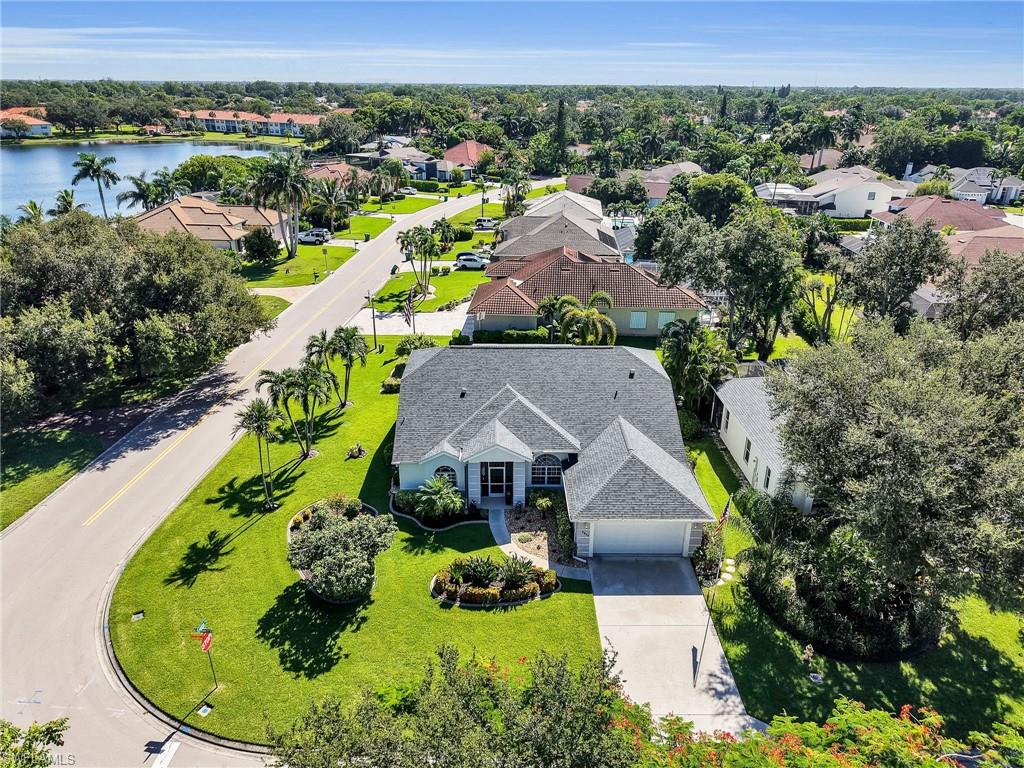 Single-story residence with an attached two-car garage, manicured landscaping, and mature trees