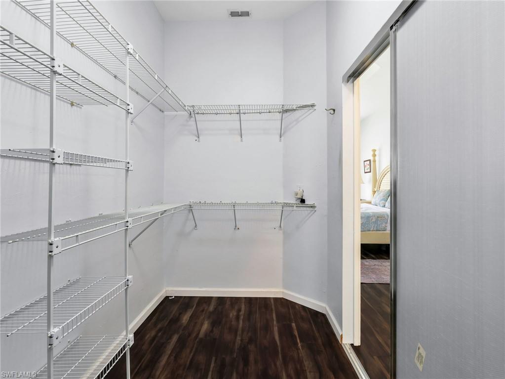 Walk-in closet featuring wire shelving, wire hanging rods, and wood-finish flooring