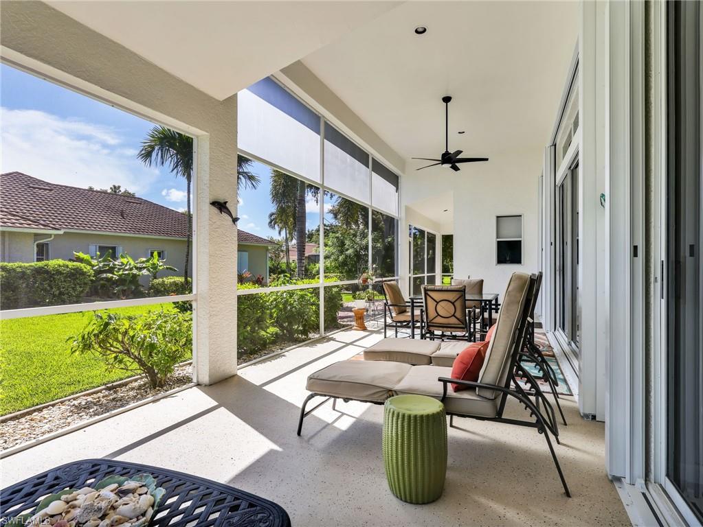 Expansive screened lanai featuring a textured concrete floor, a ceiling fan, recessed lighting, and sliding glass doors