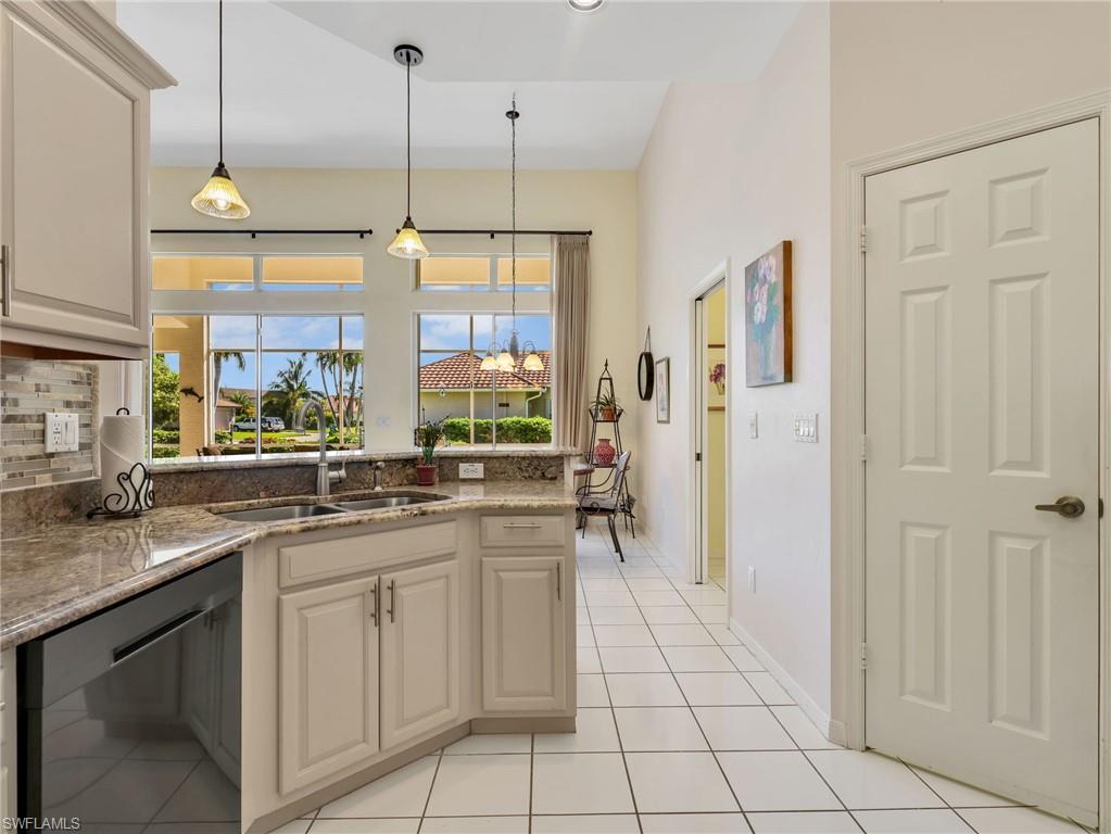 Kitchen with granite countertops, light-toned cabinetry, stainless steel sink, tile flooring, and multiple pendant lights