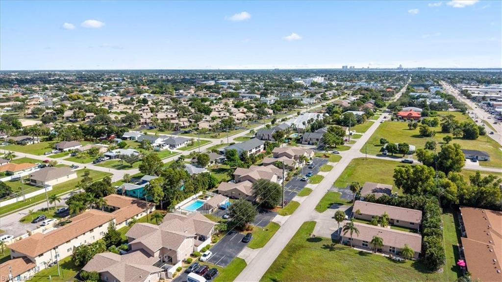 Aerial view showcasing a well-established residential community featuring tree-lined streets, spacious home sites with mature landscaping, and expansive manicured lawns throughout the neighborhood
